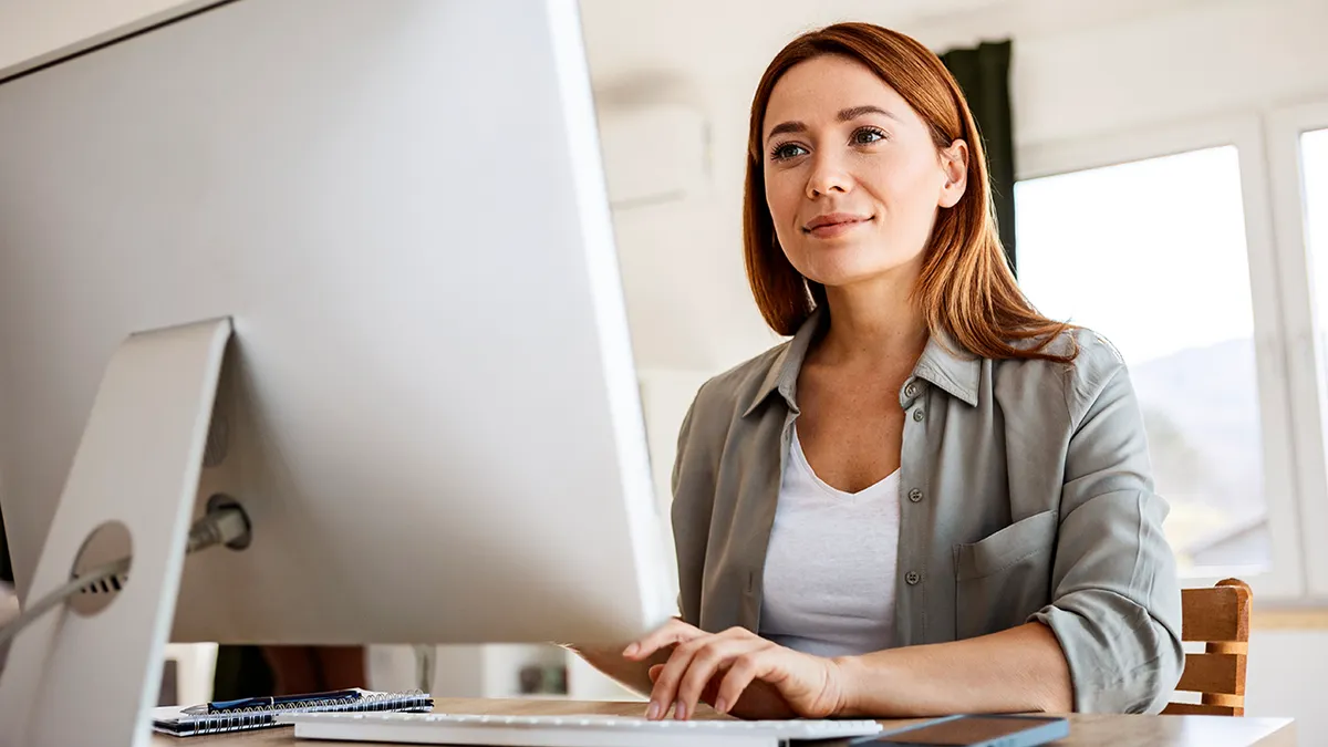 woman types on desktop computer