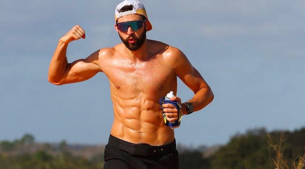 Ultra Athlete Alvaro Nunez flexing his bicep muscle while running a ultra distant marathon.jpg