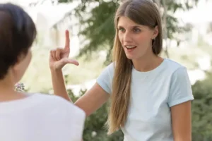 two friends conversing with each other by using sign language 300x200.webp.webp