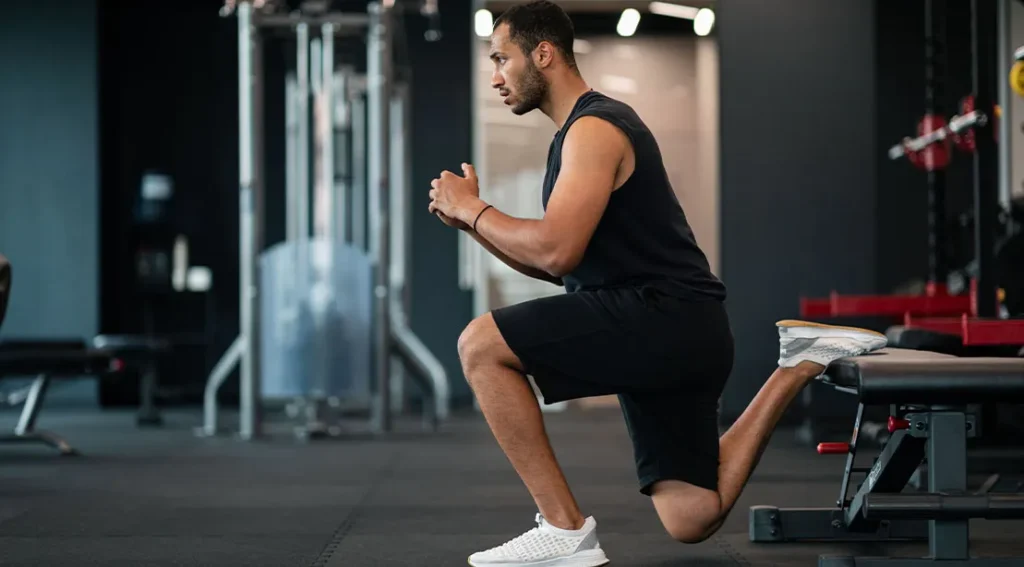 Tall athletic man performing the bulgarian split squat after reviewing the bulgarian split squat che.webp