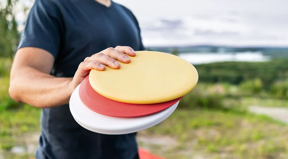 Disc Golfer holding various colored disc for disc golf.jpg