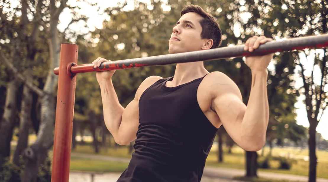 Fit Man Performing A Pullup In The Park.jpg
