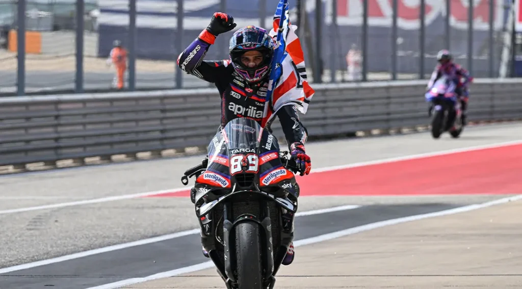 MotoGP racer and champion Jorge Martin on his bike raising his arm in victory after becoming a MotoG.webp