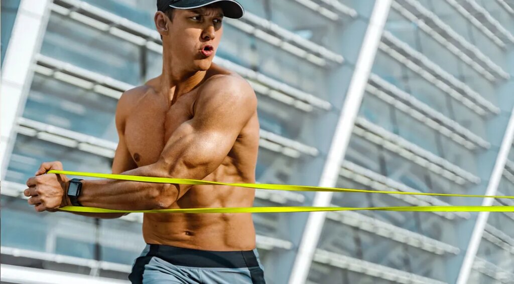Muscular athletic man performing a pallof press exercise using a resistance band.jpg