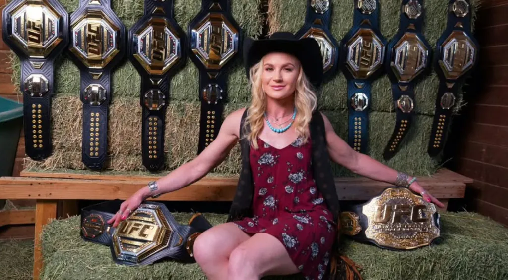 Female UFC fighter Valentina Shevchenko sitting down with ten championship belts.jpg